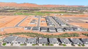 Aerial view of property and surrounding area with nearby suburban area and a mountain backdrop