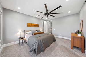 Bedroom with light colored carpet, a ceiling fan, and recessed lighting