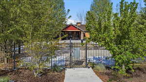 View of front of property with a fenced front yard, a gate, covered porch, and a chimney