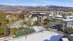Snowy aerial view featuring a mountain view and a residential view