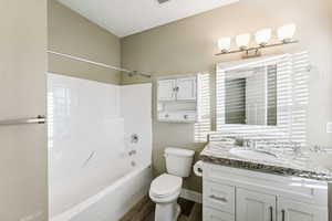 Full bath with vanity, shower / tub combination, and dark wood-type flooring