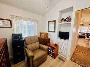 Sitting room featuring ceiling fan, light wood-type flooring, healthy amount of natural light, and lofted ceiling