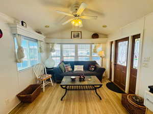 Living room with ceiling fan and light wood finished floors