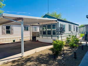Rear view of house with a carport and concrete driveway