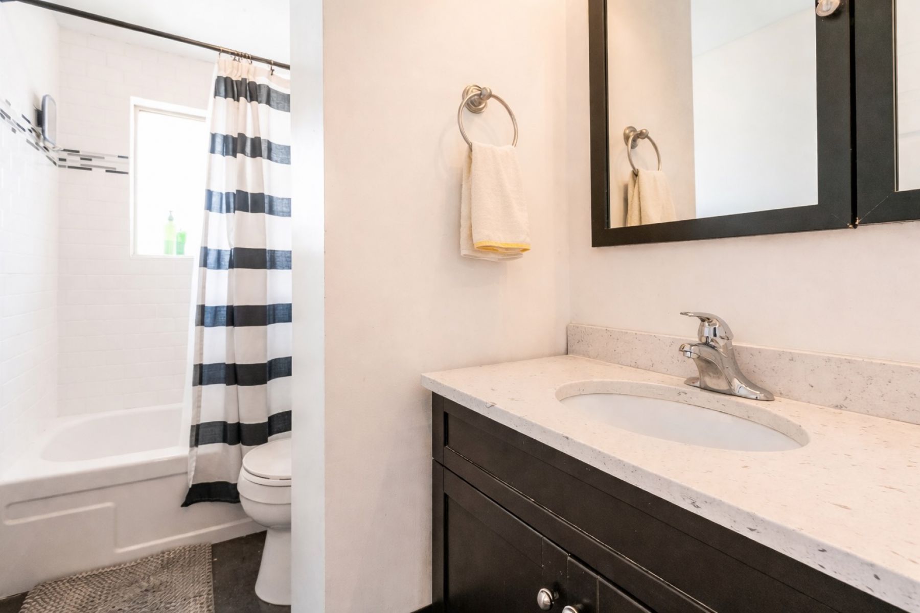 Bathroom featuring vanity and shower / bathtub combination with curtain