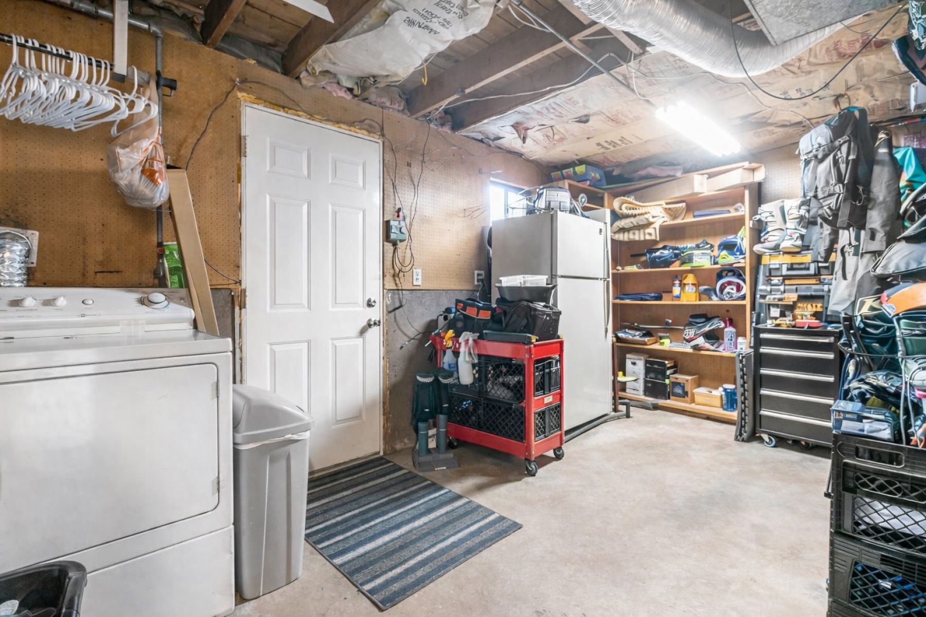 Basement featuring washer / dryer and freestanding refrigerator
