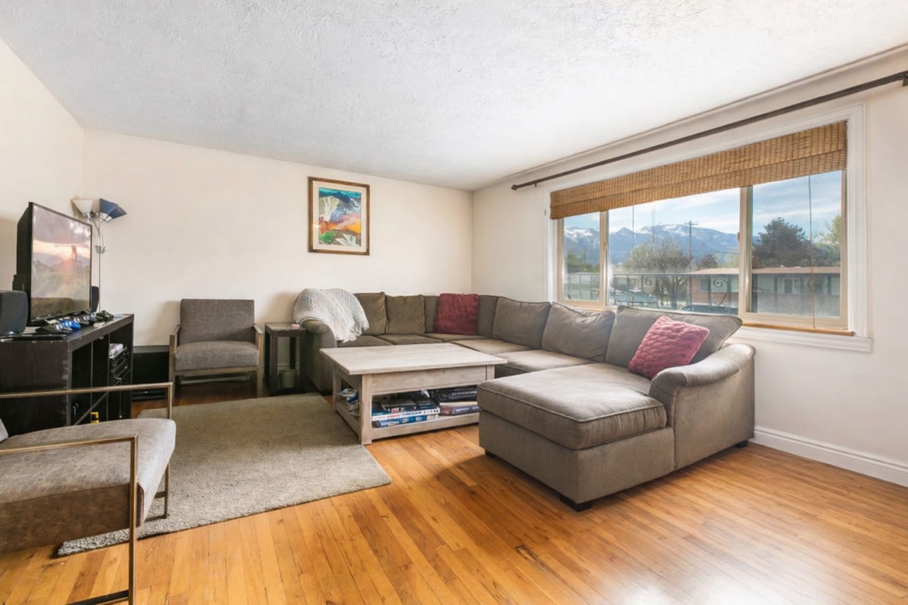Living area featuring light wood-type flooring, a mountain view, and a textured ceiling