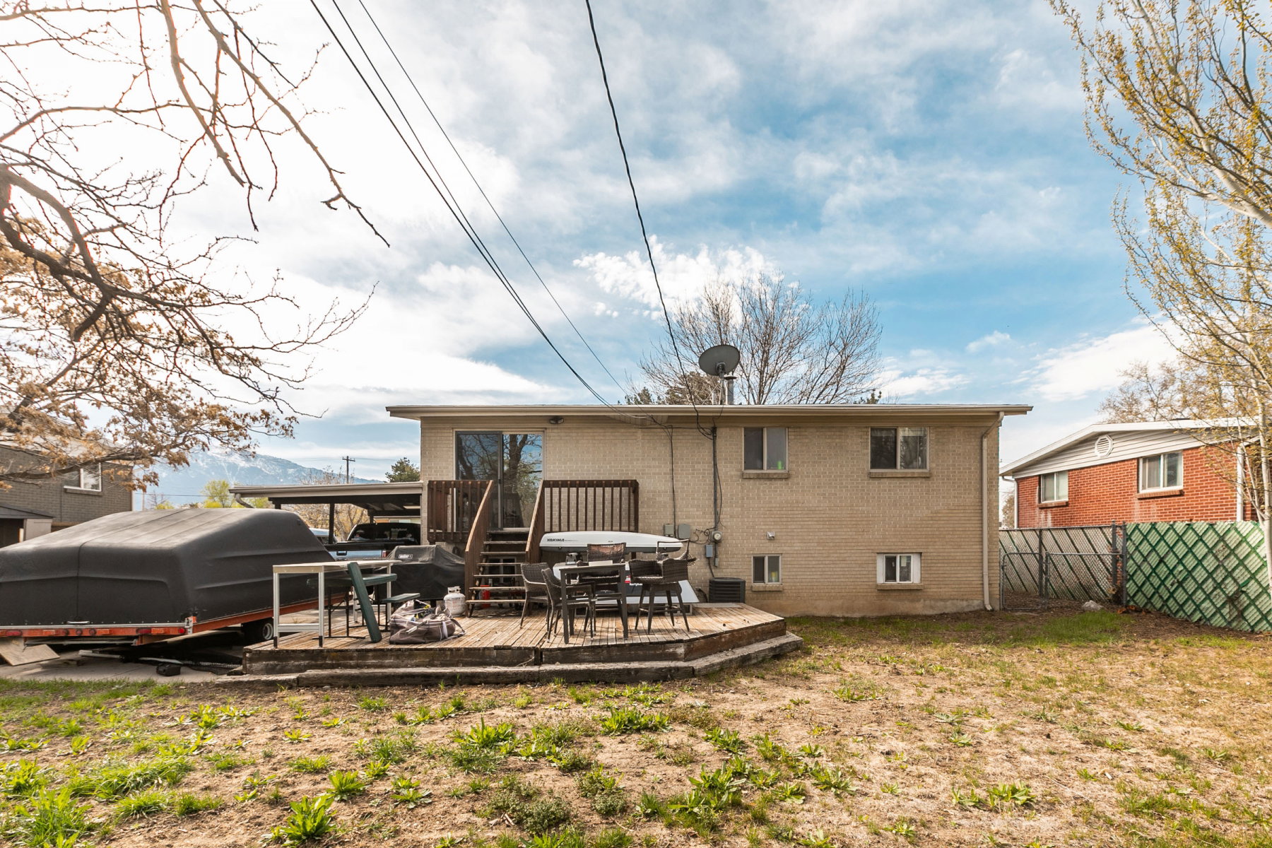 Back of property featuring a deck and brick siding