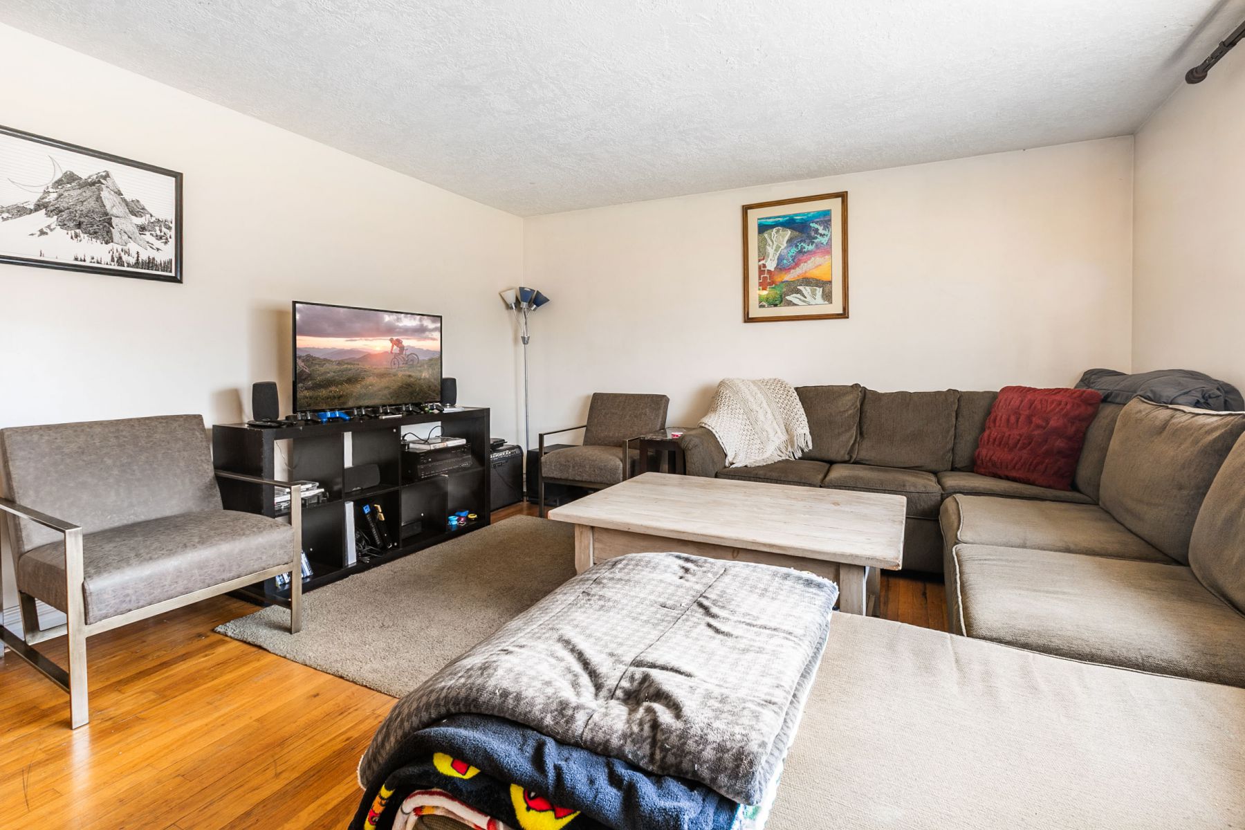 Living area featuring light wood-style flooring and a textured ceiling