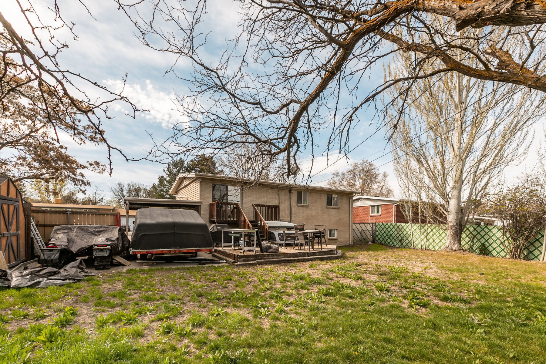 Back of house with a fenced backyard, a wooden deck, and brick siding
