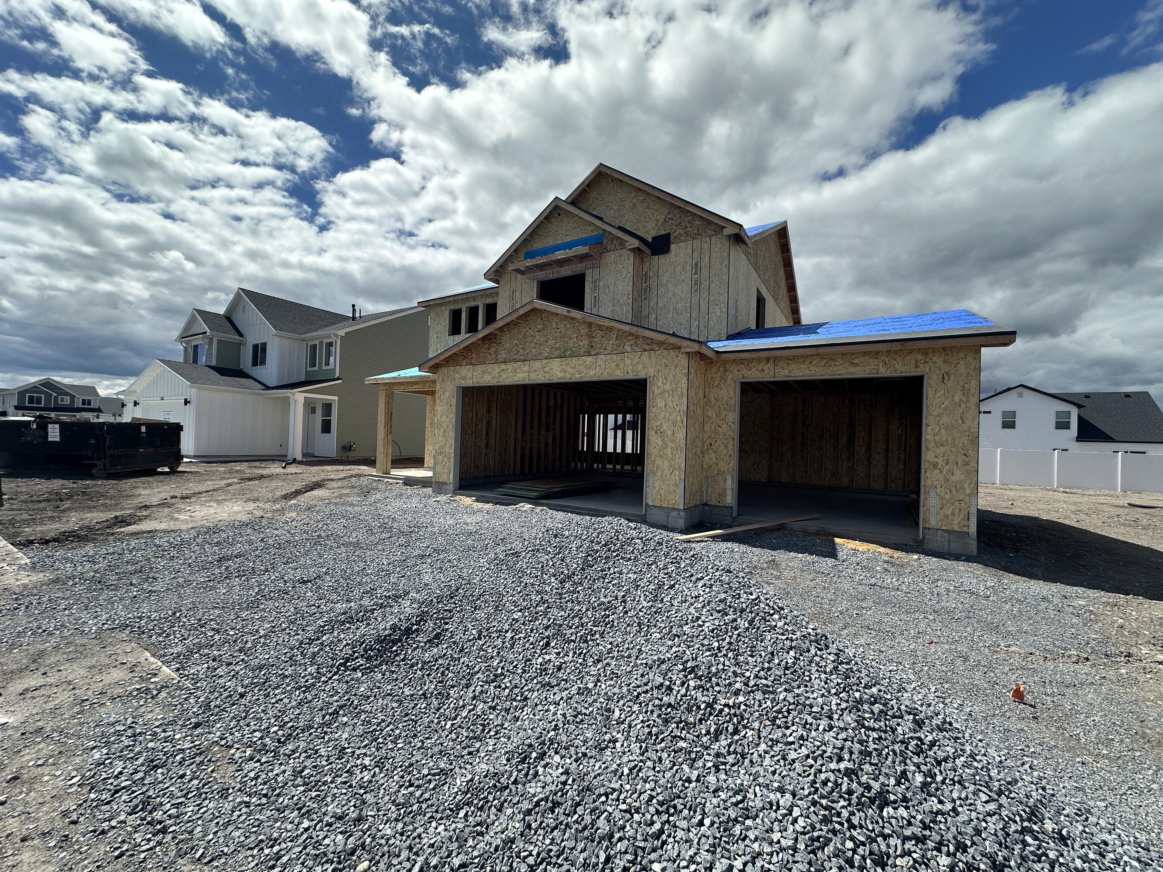 View of front of property with a residential view, driveway, and an attached garage
