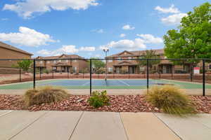 View of tennis court with a residential view