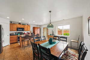 Dining area featuring recessed lighting, light tile patterned floors, and a textured ceiling
