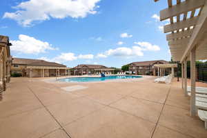 Community pool featuring a patio, a pergola, and a residential view