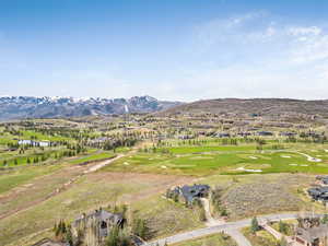 Aerial perspective of suburban area with a mountainous background and a golf club