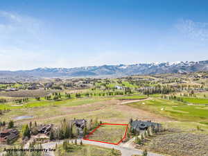 Aerial view of property's location featuring property boundaries highlighted, a golf club, and a water and mountain view