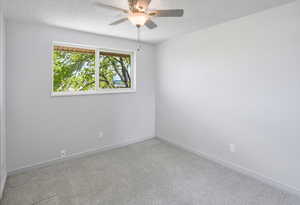 Empty room with ceiling fan and carpet flooring
