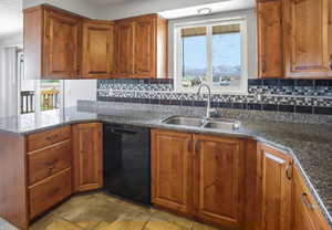 Kitchen with wood finish cabinets, dark stone countertops, dishwasher, and decorative backsplash