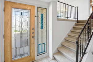 Entrance foyer featuring stairs and light tile patterned floors