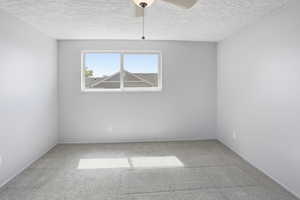 Unfurnished room with light carpet, a textured ceiling, and a ceiling fan