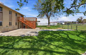 Fenced backyard featuring a patio area and a wooden deck