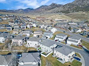 Aerial view of property and surrounding area with mountains and nearby suburban area