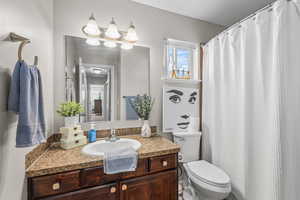 Full bathroom with vanity, a shower with shower curtain, and healthy amount of natural light