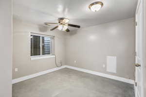Unfurnished room featuring finished concrete floors and ceiling fan