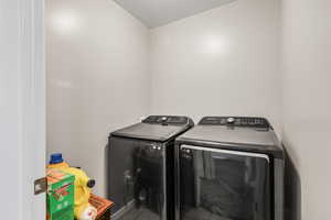 Laundry room with washing machine and clothes dryer and a textured ceiling