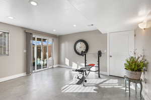 Workout room featuring finished concrete flooring and recessed lighting