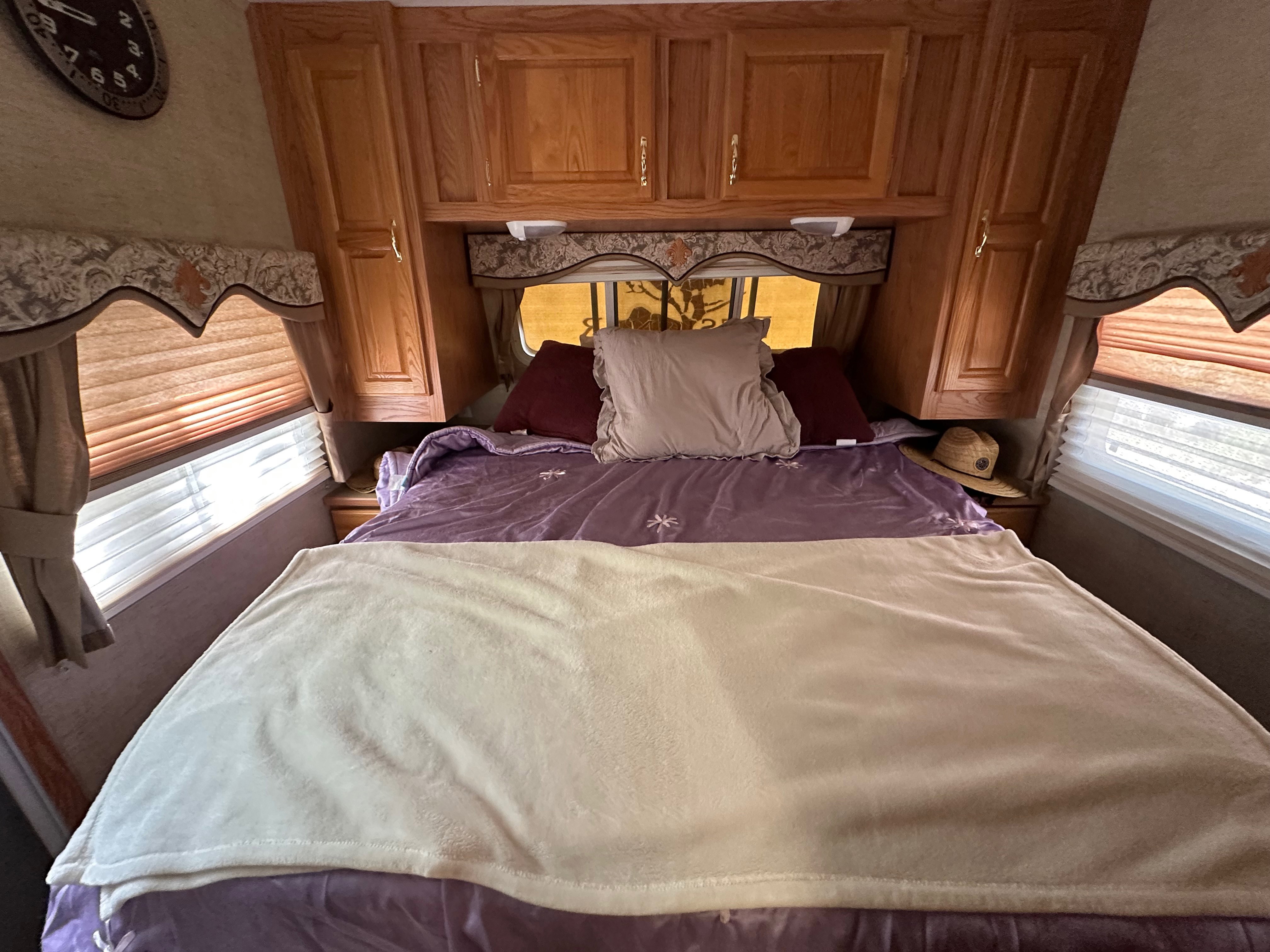 Wood-finish cabinetry and storage compartments above a built-in bed