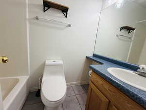 Full bath with vanity and light tile patterned floors