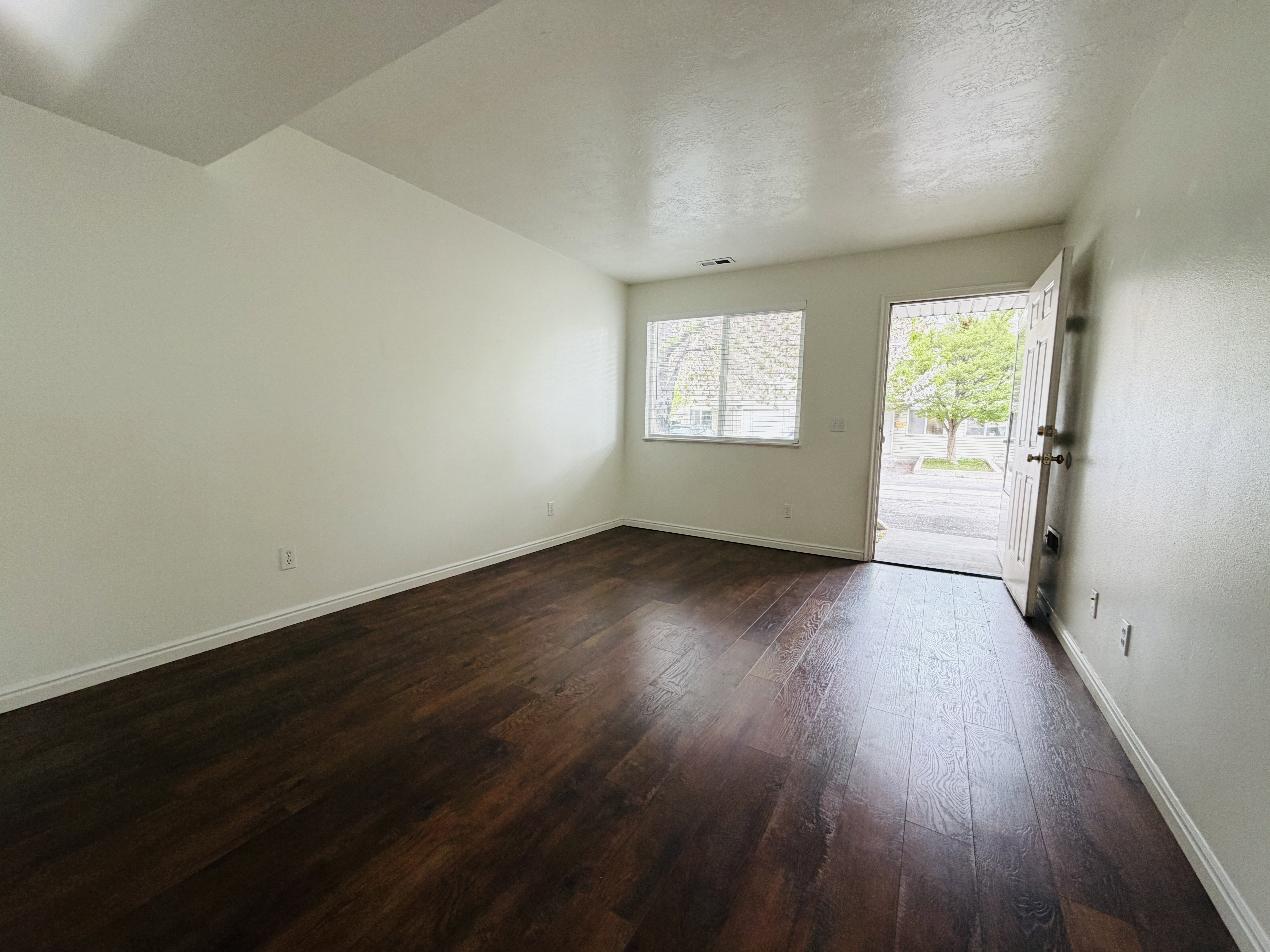 Unfurnished room featuring dark wood finished floors and a textured ceiling