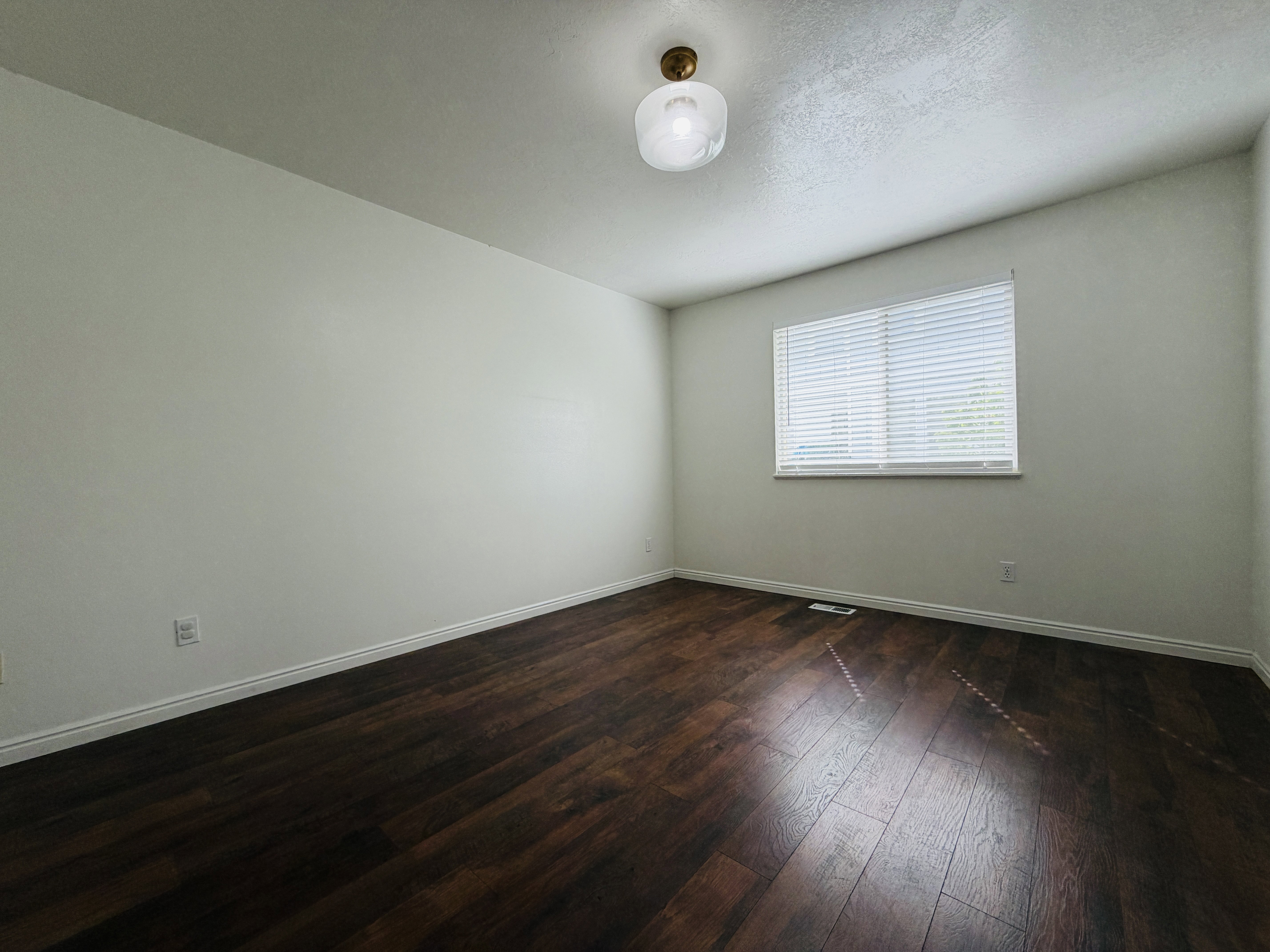 Spare room with dark wood finished floors and baseboards
