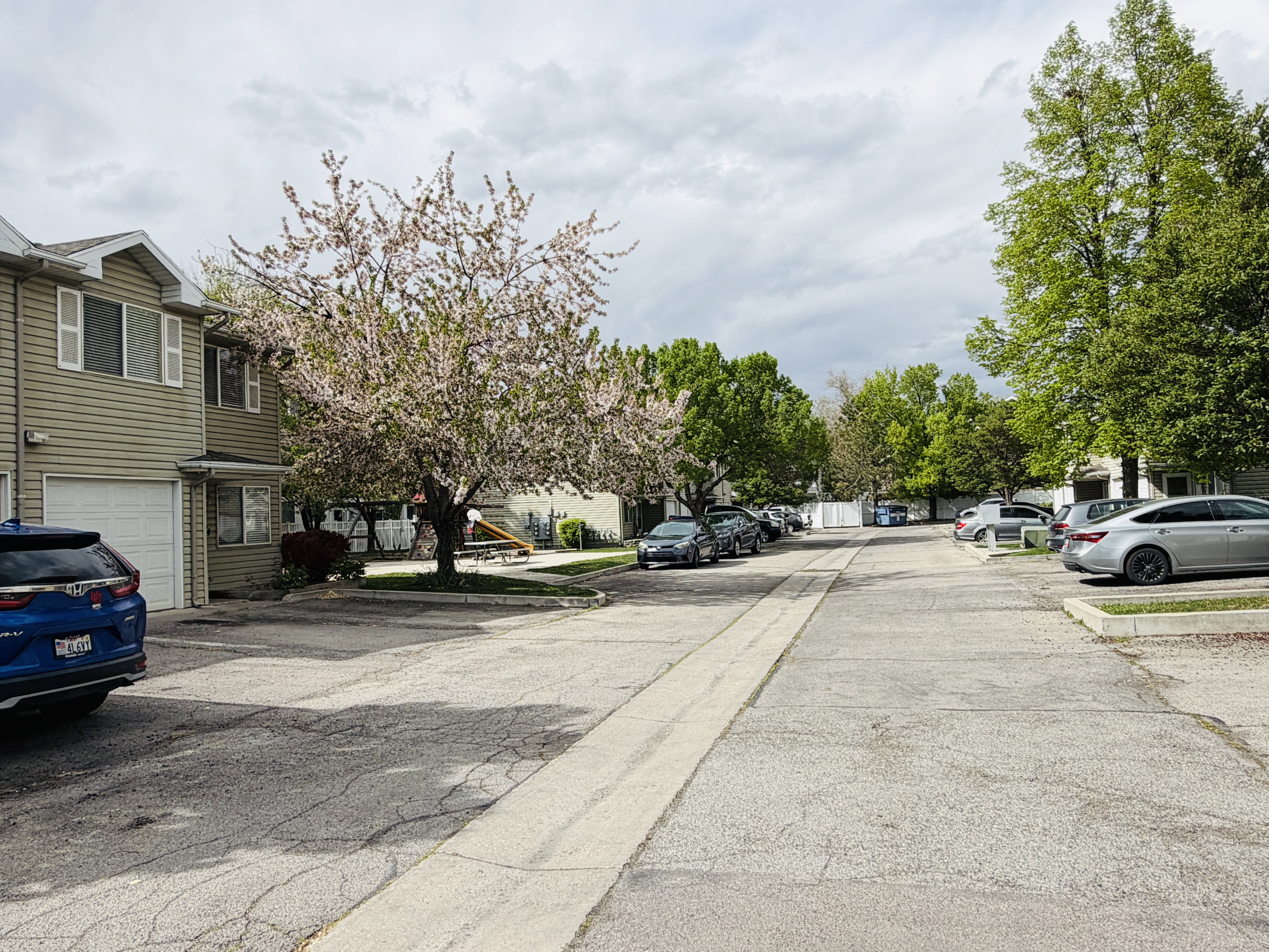 View of asphalt road with a residential view and curbs