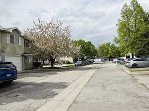 View of asphalt road with a residential view and curbs
