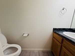 Bathroom with vanity and dark tile patterned flooring