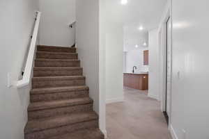 Staircase featuring finished concrete flooring and recessed lighting