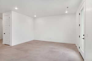 Empty room with recessed lighting and concrete floors