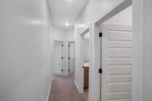 Hallway featuring baseboards and light colored carpet