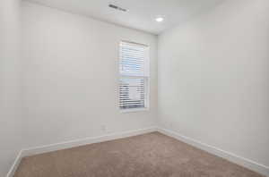 Carpeted empty room featuring baseboards and recessed lighting