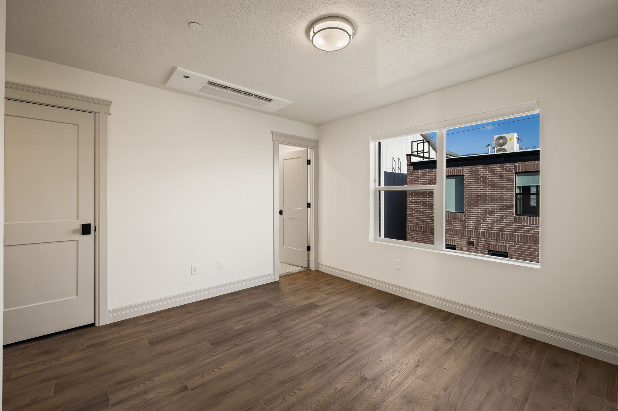Pictures of an exterior unit -Spare room with dark wood finished floors and a textured ceiling