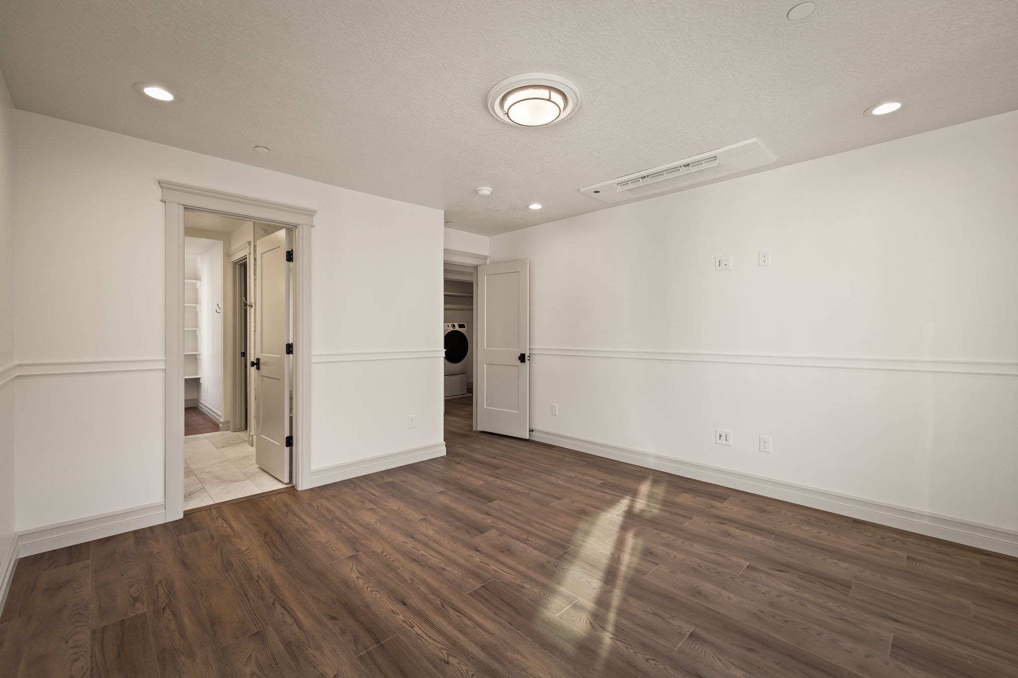 Pictures of an exterior unit -Unfurnished bedroom with dark wood-style floors, recessed lighting, and washer / dryer