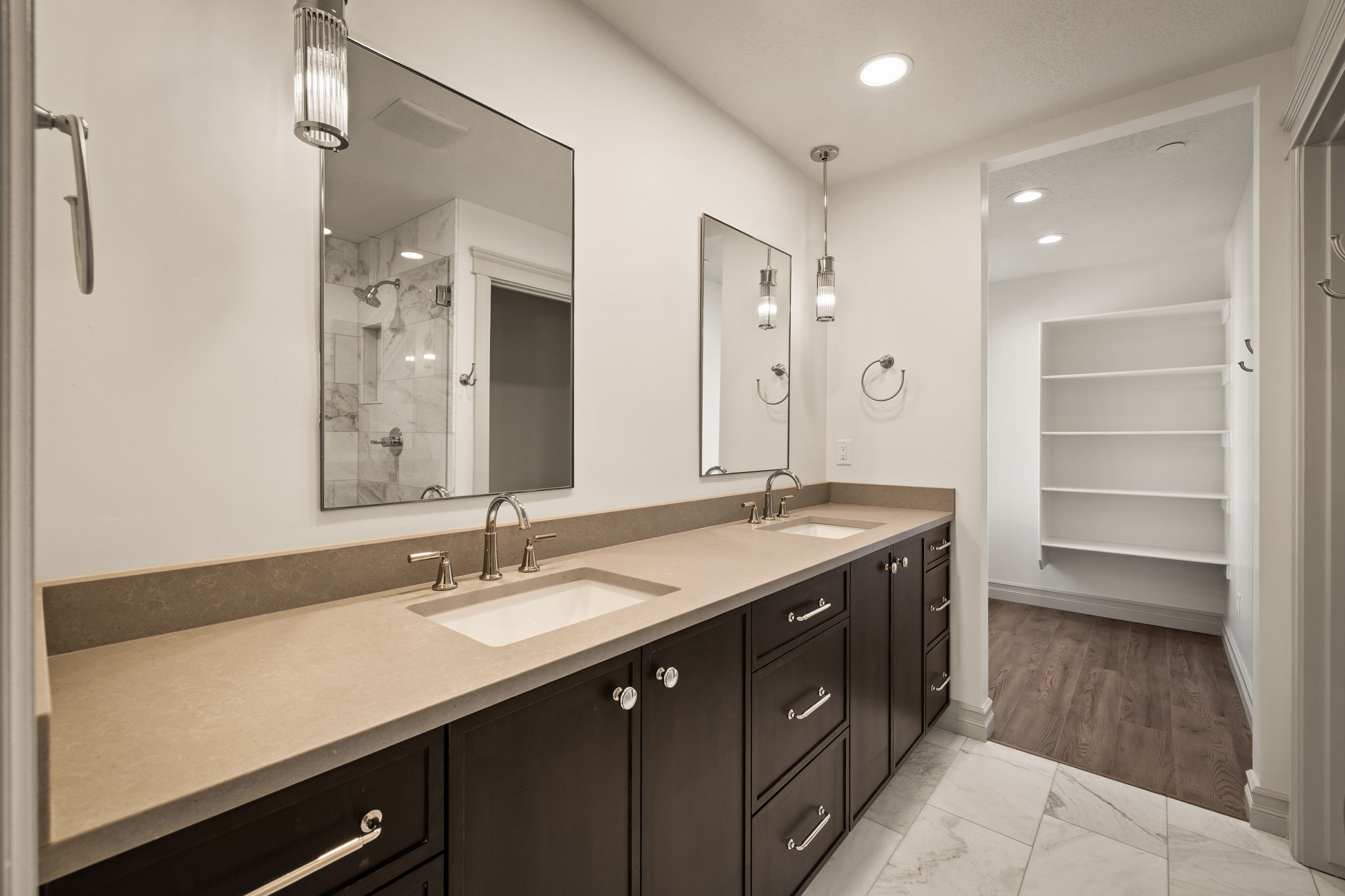 Pictures of an exterior unit -Bathroom with double vanity, light marble finish flooring, a tile shower, and recessed lighting