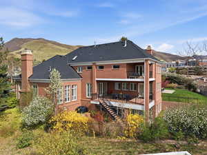 Rear view of house with a fenced backyard, a patio, and mountain backdrop