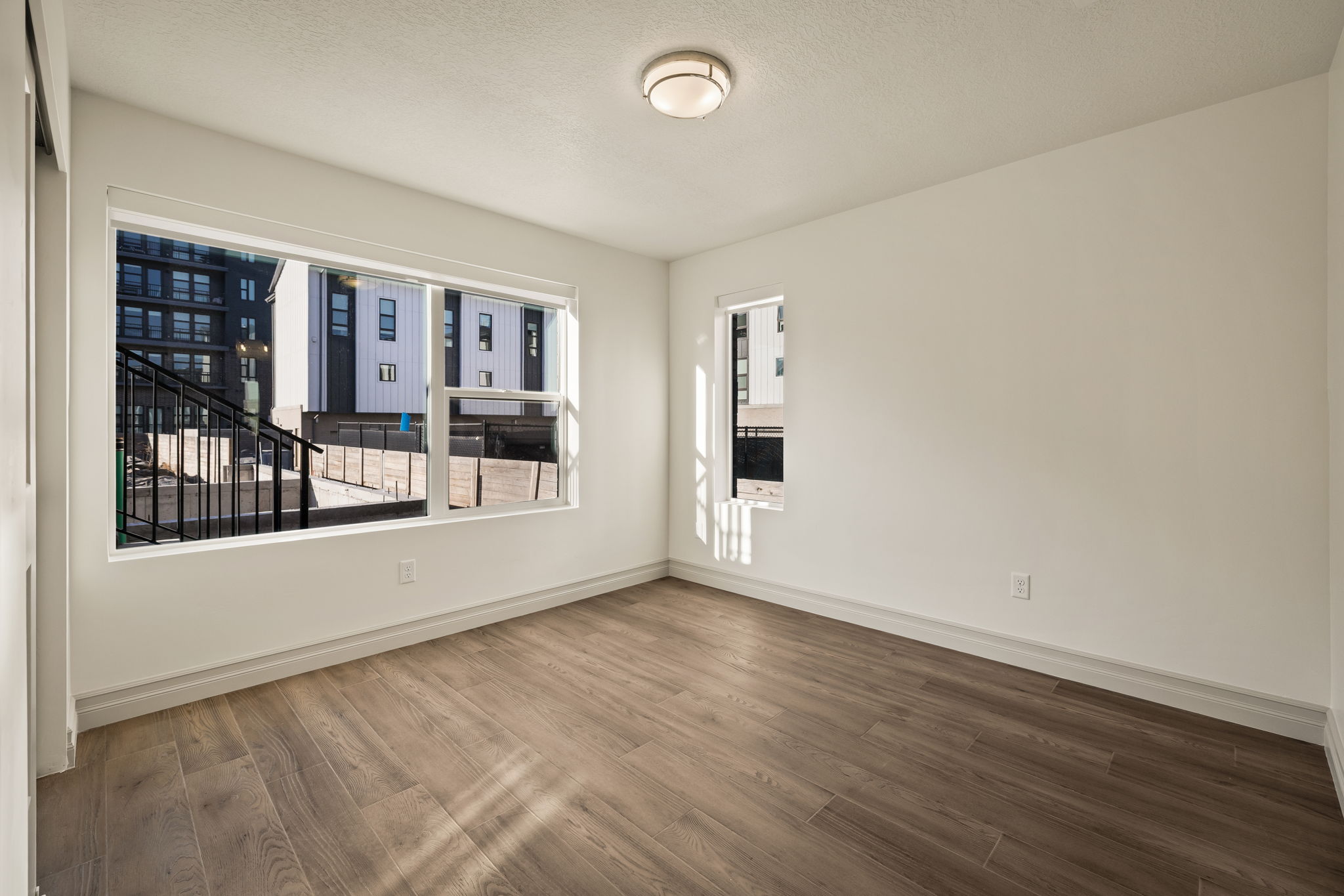 Photos of an exterior unit with the same finishes -Spare room with dark wood finished floors and a textured ceiling