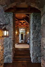 Corridor with arched walkways, dark wood finished floors, and beamed ceiling