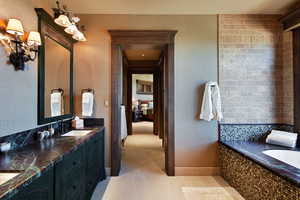 Full bath with a bath, double vanity, and light tile patterned floors