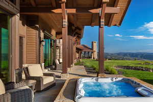 View of patio / terrace featuring a mountain view and an outdoor hot tub