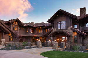 View of front facade with stone siding, a fenced front yard, a gate, and board and batten siding